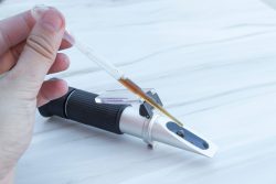 Man using a refractometer device for the measurement of an index of refraction